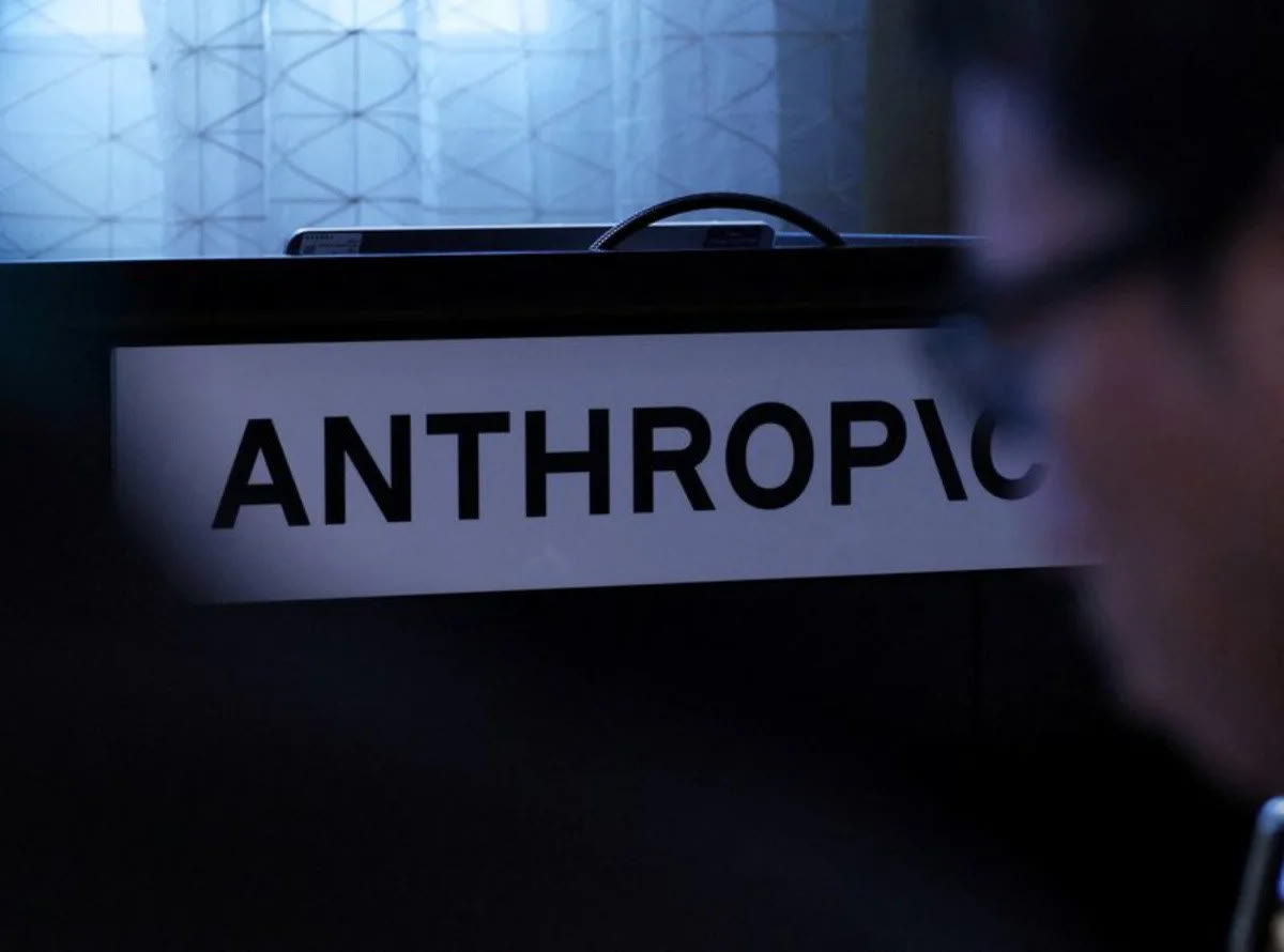 The Anthropic logo displayed on a screen at a media briefing.