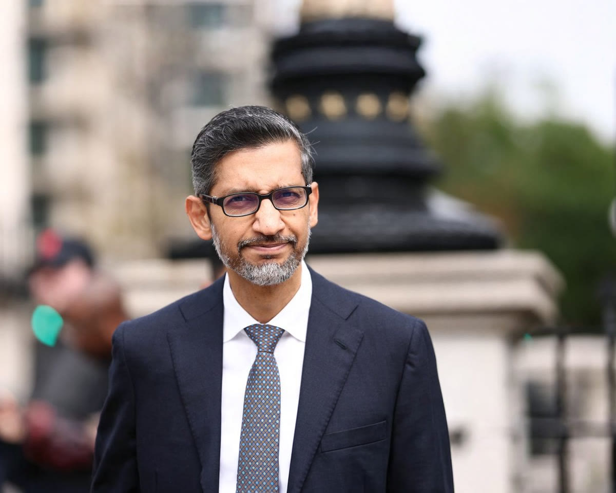 A man in a dark suit and glasses squints at an event.