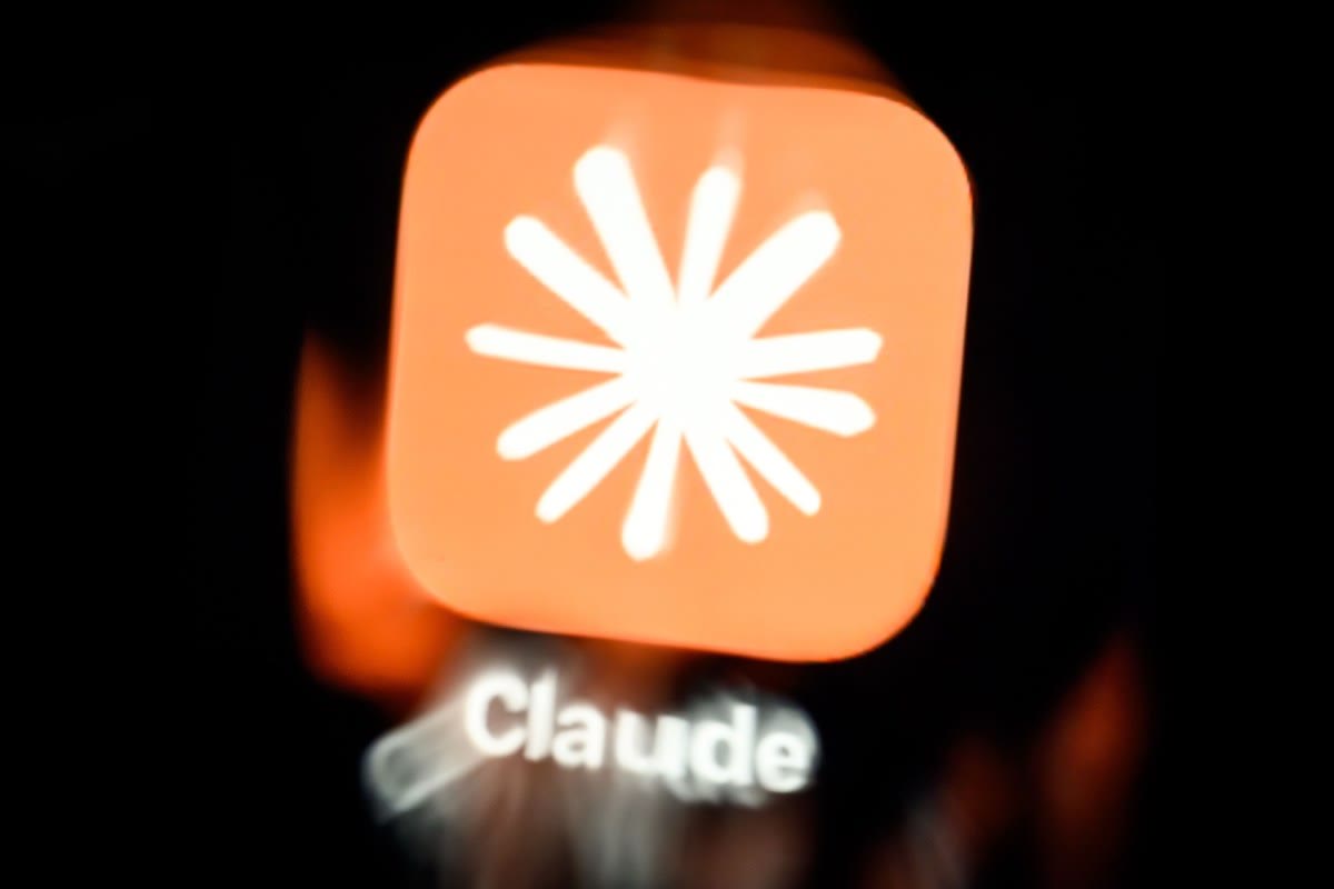 The Claude app icon seen through running water on a digital screen.
